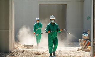Equipe de limpeza removendo entulhos e pó em obra recém-finalizada.